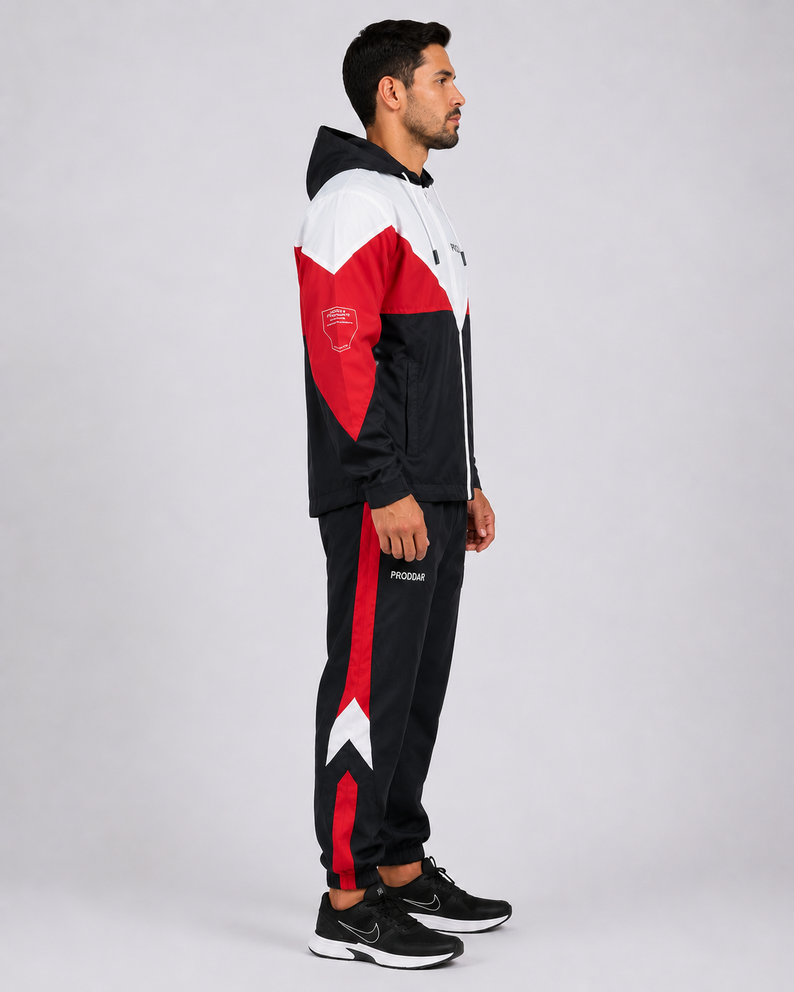 Buzo para entrenamiento con chaqueta de capucha y pantalón deportivo de diseño tricolor, vista lateral izquierda.