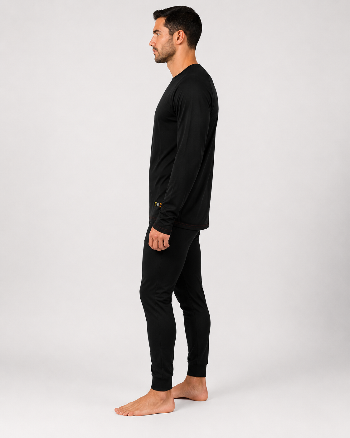Primera capa ignífuga certificada con conjunto negro de manga larga y pantalón ajustado, vista lateral derecha.