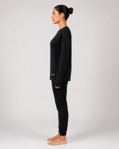 Primera capa ignífuga femenina confeccionada en jersey con camiseta de manga larga y pantalón negro, vista lateral izquierda.