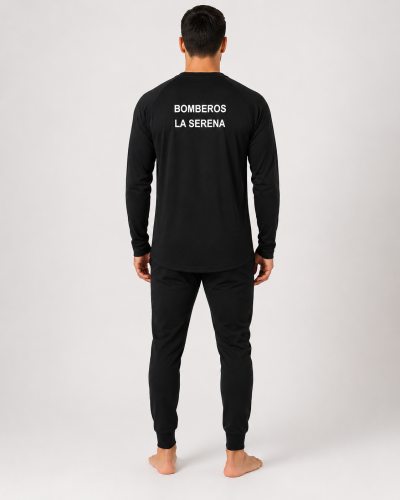 Primera capa ignífuga certificada con estampado identificatorio en la espalda y pantalón negro de ajuste anatómico, vista posterior.