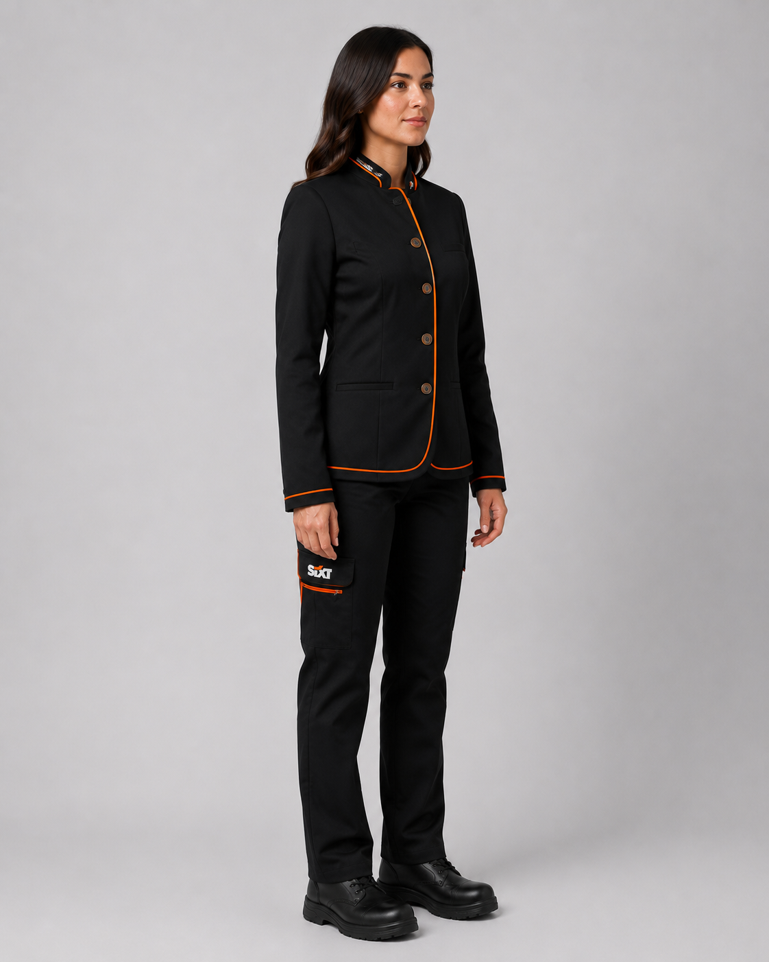 Uniforme corporativo femenino con chaqueta ejecutiva negra y pantalón cargo negro, vista lateral izquierda.