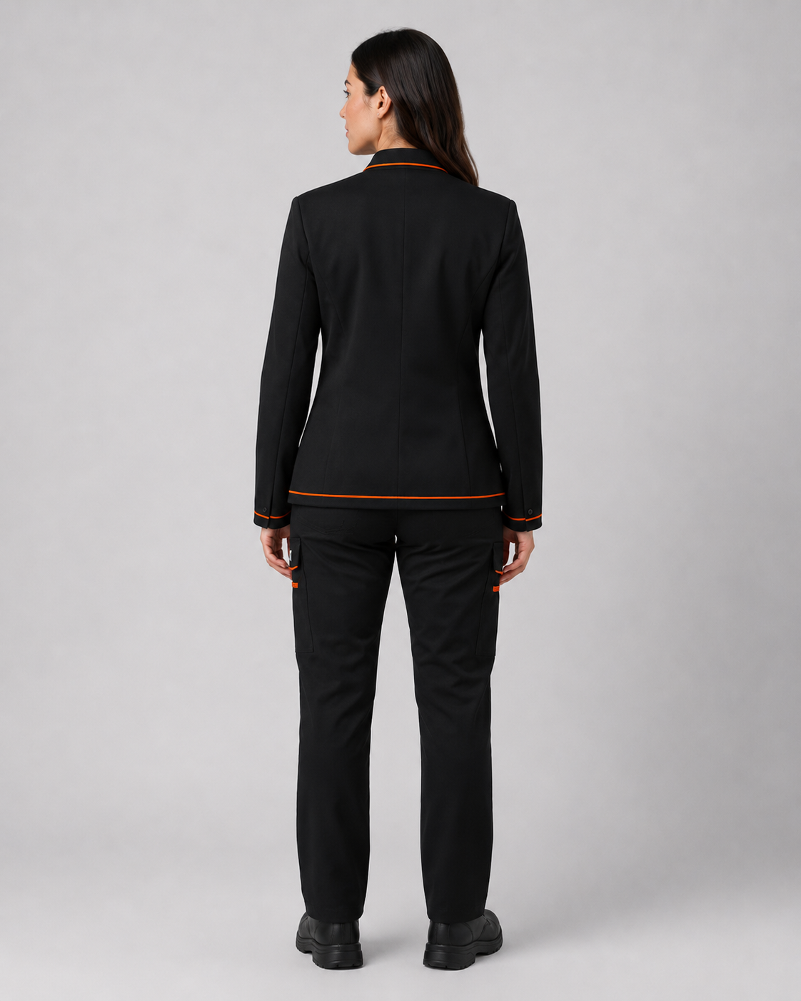 Parte posterior del uniforme corporativo femenino con chaqueta negra de corte ejecutivo y pantalón cargo negro.