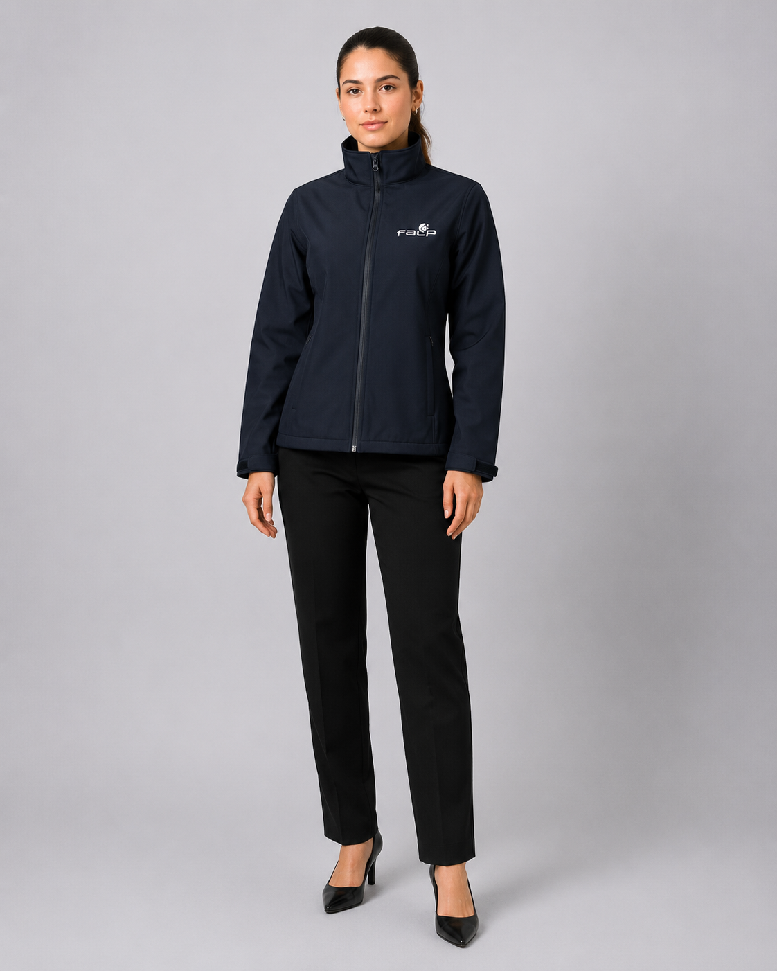 Uniforme corporativo femenino con chaqueta Softshell de cuello alto, cierre frontal y pantalón ejecutivo negro, vista frontal.