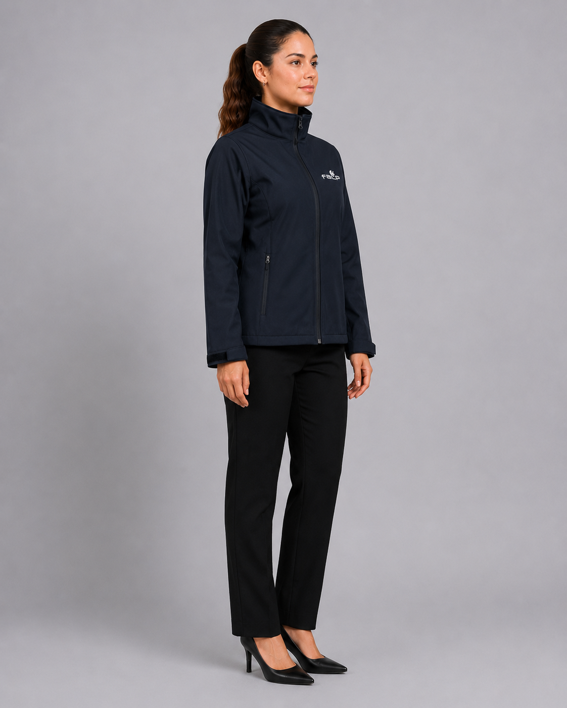 Uniforme femenino para instituciones de salud con chaqueta Softshell de manga larga y pantalón ejecutivo, vista lateral izquierda.