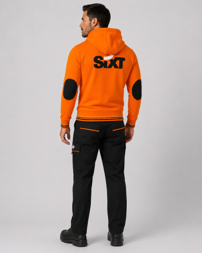 Parte posterior del uniforme corporativo con polerón naranjo con capucha, logo de gran formato y pantalón cargo negro.