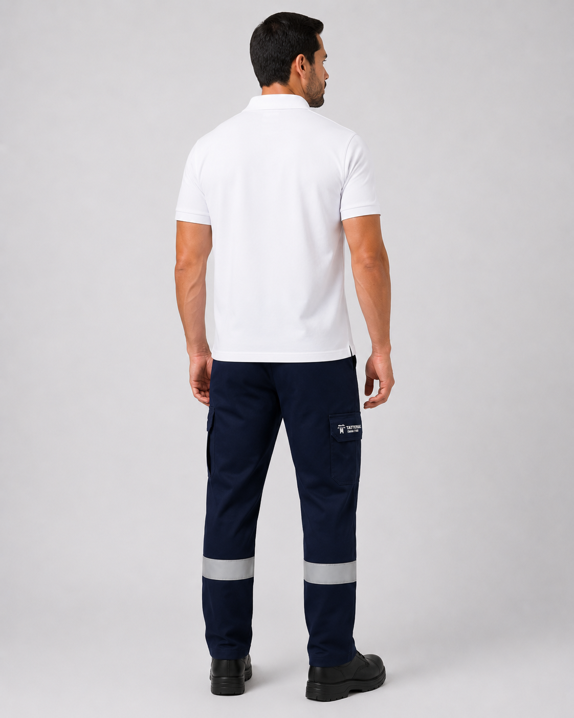 Parte posterior del uniforme corporativo compuesto por polera tipo polo de piqué de algodón blanca y pantalón cargo reflectante azul marino.