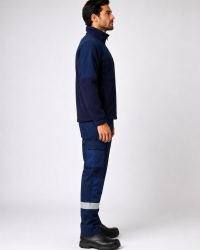 Lateral izquierdo del uniforme industrial con chaqueta softshell y pantalón cargo con zonas reforzadas y bandas reflectantes.