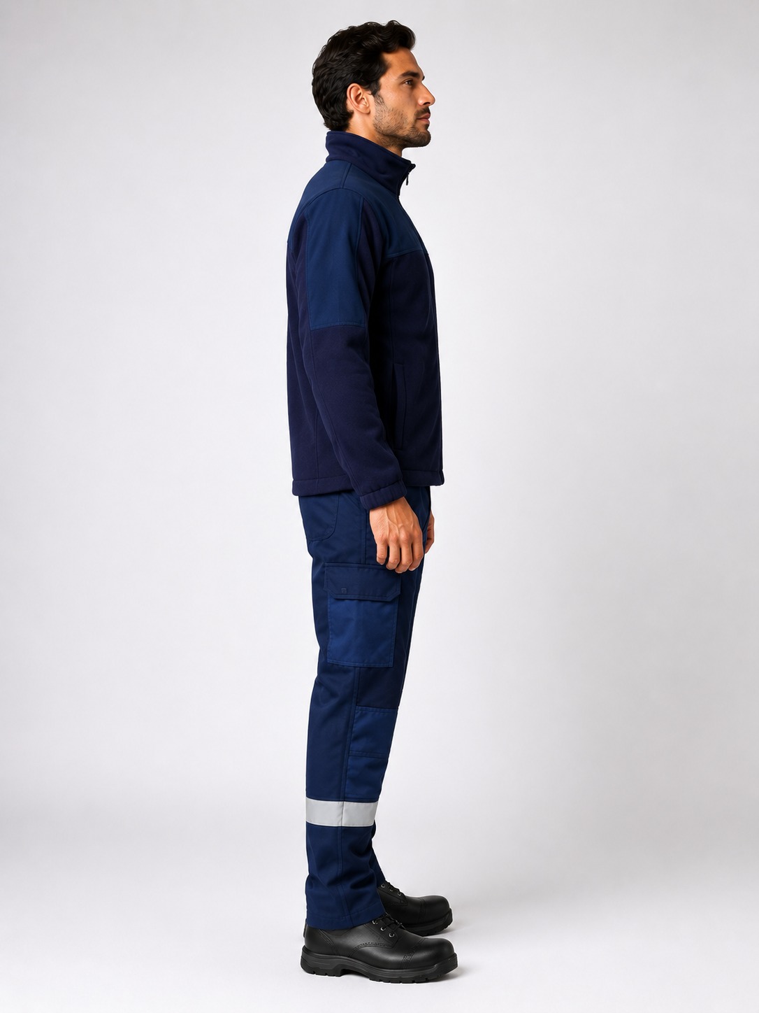 Lateral izquierdo del uniforme industrial con chaqueta softshell y pantalón cargo con zonas reforzadas y bandas reflectantes.