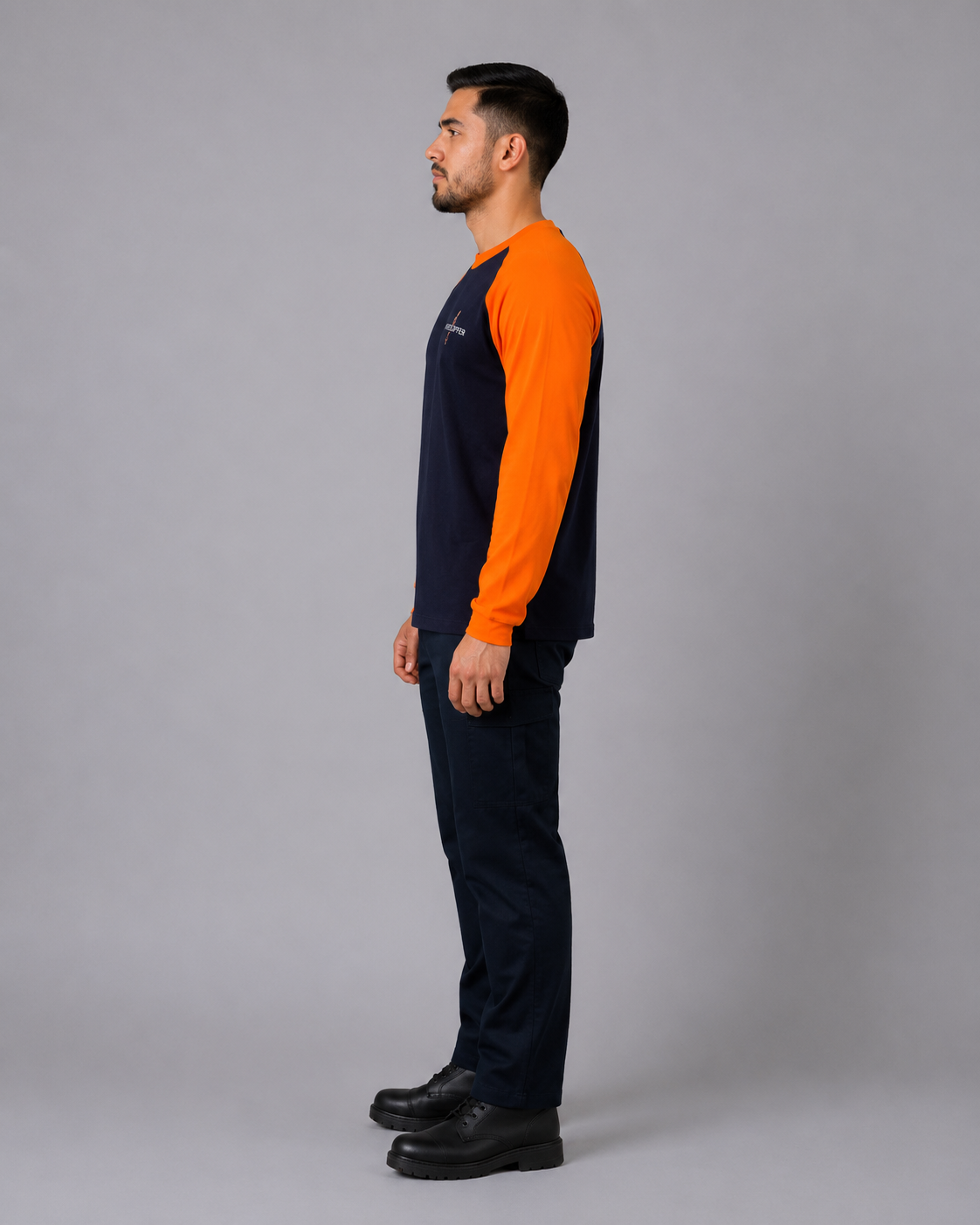 Uniforme técnico con polera manga raglán de manga larga en jersey algodón y pantalón cargo azul marino, vista lateral izquierda.