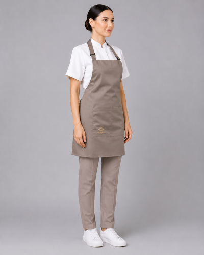 Uniforme profesional con blusa de cuello mao, pantalón recto beige y pechera de gabardina con bolsillo frontal, vista tres cuartos.
