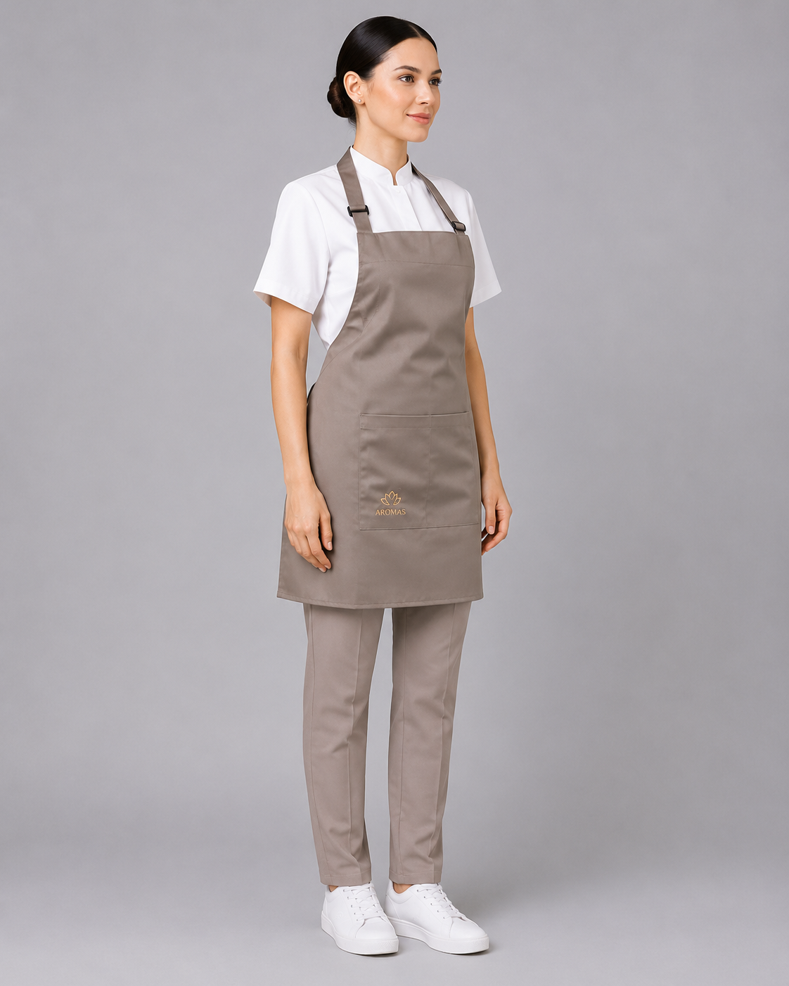 Uniforme profesional con blusa de cuello mao, pantalón recto beige y pechera de gabardina con bolsillo frontal, vista tres cuartos.